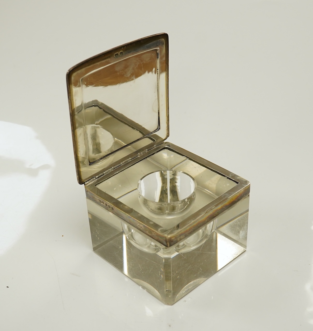 A George V silver lidded glass square inkwell, by Henry Matthews, Birmingham, 1929, width 95mm. Condition - poor to fair